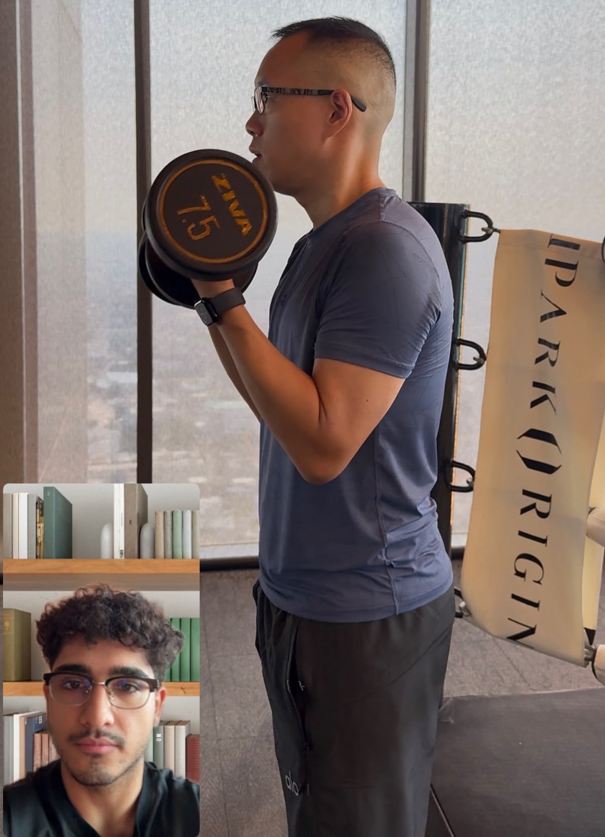 Client on a live video call with an online personal trainer, performing a dumbbell bicep curl