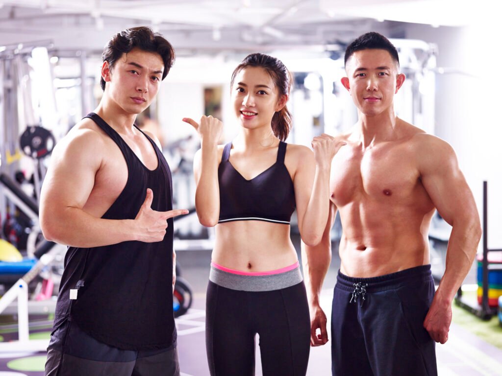 Client posing with trainers in the gym