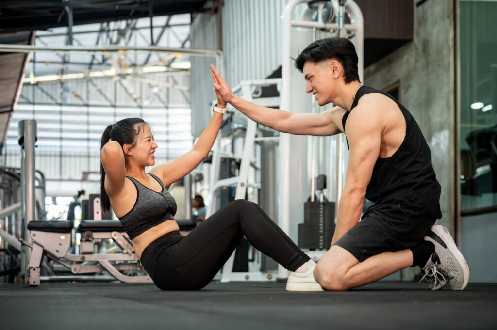Trainer giving a client a high five during a workout